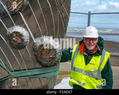 Musselburgh, East Lothian, Ecosse, Royaume-Uni, le 14 juin 2018. L'installation de sculpture par Michael Johnson, qui ses boulons en acier inoxydable de 2 tonnes sculpture 'Mémoire et réflexion" en place dans Murdoch vert. La coquille des moules en bronze poli à la main sculpture a cartouches représentant l'histoire de la ville et mesure 14 m de haut par 6 pieds de large. Conçu et construit par la Bretagne, sculpteur, il est commandé par l'East Lothian Council dans le cadre de sa politique des arts de pour cent et financé par Tesco. Le sculpteur a lutté avec Hector tempête Vent comme il a été placé. L'installation du sculpteur sculpture Banque D'Images