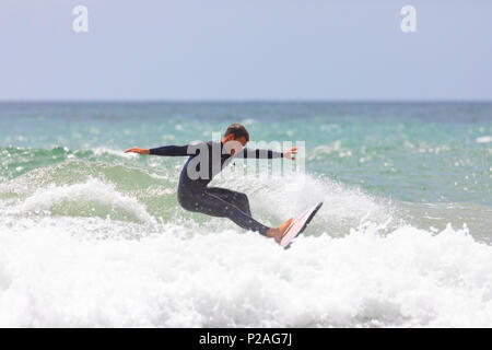 Surfeur de Whitsand Bay Trystan Hopgood équitation les vagues sur une chaude journée d'été près du village de Freathy, Cornwall, UK Banque D'Images