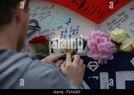 L'ouest de Londres. Londres. Royaume-uni 14 juin 2018 - Les membres de famille de déposer des couronnes, des fleurs et de l'éclairage de bougies à la base de la tour de Grenfell en dehors du centre de loisirs de Kensington. L'incendie a éclaté le 14 juin 2017 dans les 24 étages de la tour de Grenfell bloc appartements de logement public dans le nord de Kensington, l'ouest de Londres, dans lequel 72 personnes ont perdu la vie. Credit : Dinendra Haria/Alamy Live News Banque D'Images