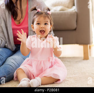 Happy baby girl avec la mère à la maison Banque D'Images