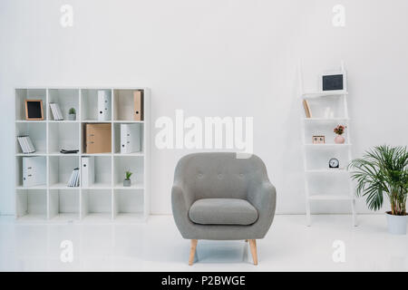 L'intérieur de bureau moderne avec fauteuil gris et des dossiers sur des étagères Banque D'Images