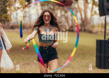 Belle Jeune femme jouant avec ruban stick au festival de musique. Hipster femme bénéficiant à fête de la musique. Banque D'Images