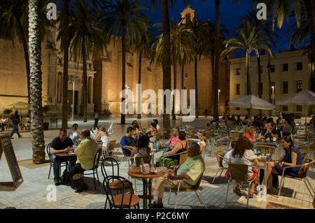 Plaza en face de la cathédrale avec des palmiers et des gens à des tables éclairées en soirée, Almeria, Andalousie, Espagne Banque D'Images