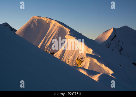 Deux Alpinistes sur l'arête sommitale de la Roccia Nera, l'un des cinq sommets du Breithorn massif, au-dessus d'eux de grandes corniches en th Banque D'Images