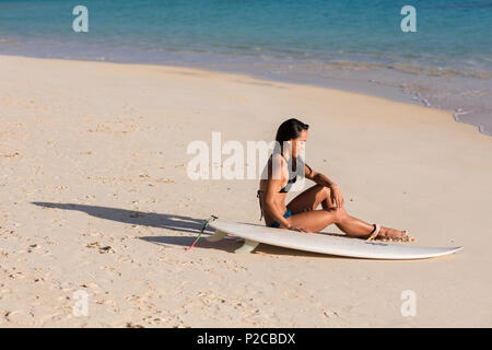 Woman relaxing with surfboard dans la plage Banque D'Images