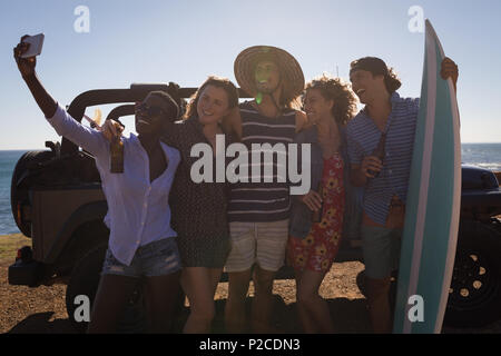 Groupe d'amis en tenant avec selfies téléphone mobile Banque D'Images