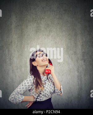 Happy young woman talking on retro téléphone sur wall background Banque D'Images