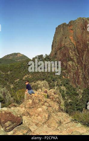 Un enfant pose par Bluff dans le Grand Cratère hauts sommets, Warrumbungle National Park, New South Wales, Australie. Parution du modèle Banque D'Images