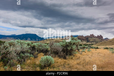 Paysage aride des prairies de parc d'état de Buffalo Bill au crépuscule avec l'armoise, herbes sèches, et les formations rocheuses à l'horizon, Cody, Wyoming, USA. Banque D'Images