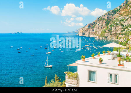 White villa de vacances avec balcon et toit-terrasse face à la mer Méditerranée avec les montagnes en arrière-plan aux beaux jours de l'été, Positano, Amalfi coast Banque D'Images