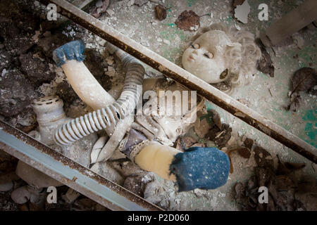 Poupée ancienne placée sous deux poutres métalliques dans un jardin d'enfants abandonnés dans la région de Pripyat - nucléaire de Tchernobyl zone d'aliénation. L'un de ce métal être Banque D'Images