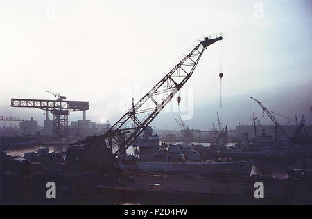 . Le crépuscule tombe sur le quai des États-Unis New York Navy Yard, Brooklyn, New York (USA), vers juin-septembre 1943. Le navire dans le centre, juste au-delà de la grue, est USS Gherardi (DD-637). USS Luce (DD-522) est à gauche, avec seulement son arc visible. USS Butler (DD-636) est à droite, avec seulement sa poupe visible. USS Doyle (DD-494) est dans l'arrière-plan droit. Un croiseur léger britannique, peint en jaune, l'amorceur est à gauche, en arrière-plan. Entre juin 1943 et septembre 1943. Nsu 8 Brooklyn Navy Yard au crépuscule 01 en 1943 Banque D'Images