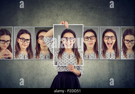 Girl détient et changer son visage portraits avec différentes expressions. Femme exprimant différentes émotions Banque D'Images