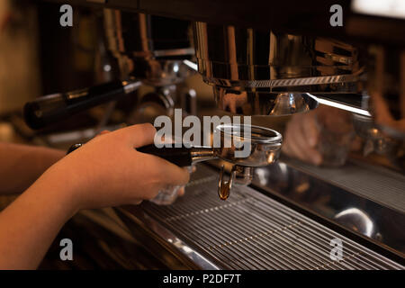 Barista holding portafilter rempli près de machine à expresso Banque D'Images