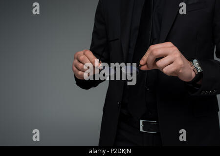 Vue partielle de male hands holding glasses isolé sur gray Banque D'Images