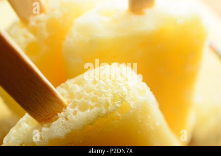 Gros plan (macro) de l'ananas jaune congelé fait maison sucettes glacées (Popsicles) avec poignées en bois. Banque D'Images