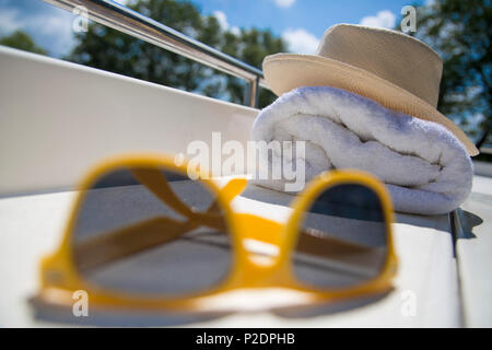 La vie toujours avec des lunettes de soleil, chapeau jaune et la serviette sur le pont du bateau péniche Le Royal mystique sur le canal de Bruges - Ostende, près de Banque D'Images