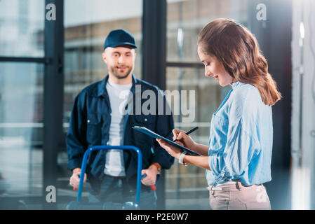 Femme avec de l'eau réceptrice du presse-papiers de livraison par messagerie Banque D'Images
