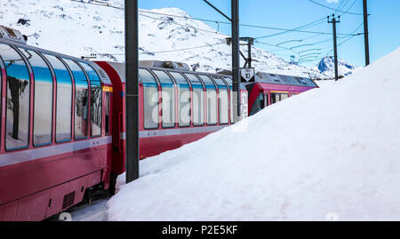 Train Bernina Express, l'un des plus élevés de fer dans le monde, va à travers la montagne enneigée entre l'Italie et la Suisse Banque D'Images