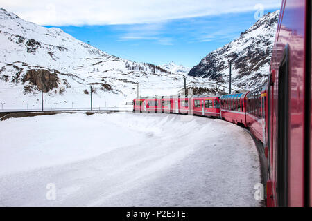 Train Bernina Express, l'un des plus élevés de fer dans le monde, va à travers la montagne enneigée entre l'Italie et la Suisse Banque D'Images