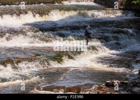 L'homme dans les bottes cuissardes de pêche dans la rivière à un barrage Photo Stock - Alamy