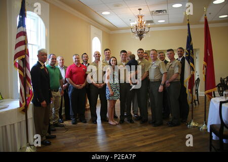 Une famille militaire pose avec des représentants du commandement et des responsables locaux de la chambre de commerce lors d'une réception à New Bern, en Caroline du Nord, en les honorant en tant que famille militaire du quartier. L'événement reconnaît les contributions au corps des Marines et à la communauté locale, mettant en valeur le service, le bénévolat, le dévouement et l'engagement. Des récompenses, des cadeaux et des certificats sont présentés dans le cadre de la cérémonie. Banque D'Images