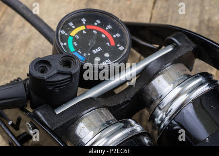 Pompe à pied et vélo sur un tube de Workbench. Accessoires pour pneus de vélos et de réparation. Fond sombre. Banque D'Images