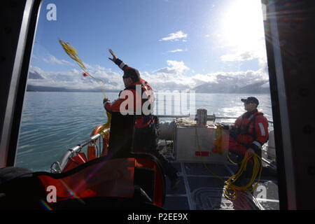 Officier de 3e classe John Patty Gerbrands, un membre de l'équipe de la station de la Garde côtière canadienne, Valdez se soulève une ligne de sauvetage à bord du 45 pieds à un collègue Réponse Boat-Medium gare 25 pieds au cours de l'équipage navigant Réponse Boat-Small la formation de qualification à Valdez Harbour à Prince William Sound, Alaska, le 13 septembre 2016. La station a effectué une série d'homme à la mer, remorquage et évolutions en cours d'ingénierie casualty. U.S. Coast Guard photo de Maître de 1re classe Bill Colclough. Banque D'Images