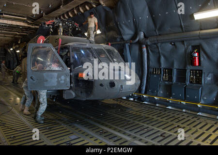 Aviateurs affecté à la 921e Escadron d'intervention d'urgence aider les soldats affectés à la 3e Bataillon, 4e Régiment d'aviation de déchargement, les hélicoptères UH-60 Black Hawk à partir d'un C-5 Galaxy au Fort Carson Air Terminal, Colorado, le 11 septembre 2016. Les soldats de retour d'une période de neuf mois de déploiement en Afghanistan. Le 921e CRS aviateurs ont été au Colorado qui participent à l'exercice grève Cerberus 16-02. (U.S. Air Force Photo par le Sgt. Joseph Swafford) Banque D'Images