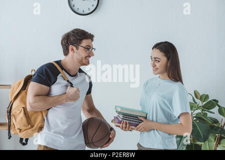 Couple d'étudiants multiethnique avec sac à dos, le basket-ball et de livres Banque D'Images