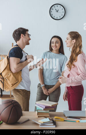 Les jeunes élèves heureux de parler ensemble et permanent Banque D'Images