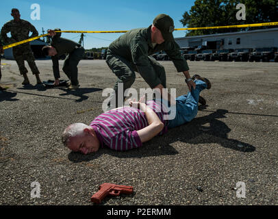 Membre de l'équipe de réaction particulière, District militaire de Washington, inspecte les 1er Sgt. Donald Rackley, premier chef de l'enrôle 733e Bataillon de la Police militaire (Division des enquêtes criminelles), qui prétendait être un preneur d'otages au cours de la protection de Capital 2016 à Fort Belvoir, Virginie, le 14 septembre. Environ 15 réserves de l'armée américaine d'enquête criminelle des agents spéciaux formés aux côtés de 25 agents en service actif pour la première fois dans un exercice d'entraînement commun connu sous le bouclier de la capitale, l'accent sur le traitement des lieux du crime, la gestion des preuves et des négociations d'otages, qui a eu lieu du 13 au 15 septembre. La réserve Banque D'Images