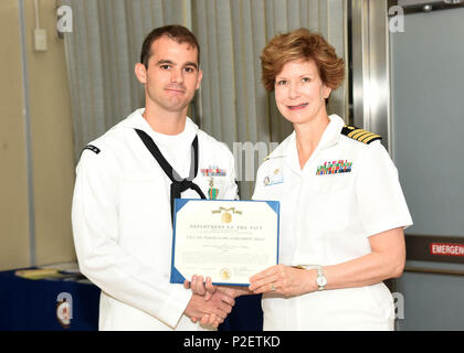 YOKOSUKA, Japon (sept. 13, 2016) - l'hôpital de la marine américaine (USNH) Yokosuka Commandant, le capitaine Rosemary C. Malone (à droite), remet la Marine et le Marine Corps Médaille militaire (NA) à l'hôpital Corpsman 2e classe Joshua Blanchard pour sauver la vie d'une mère de la noyade pendant son affectation temporaire (Service répondeur) à Surface Warfare Medical Institute (SWMI) à San Diego, Californie (US Navy photo par USNH Le Bureau des affaires publiques de Yokosuka/libérés) Banque D'Images