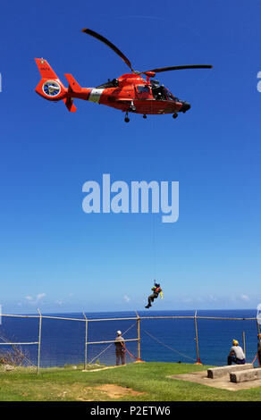 Les équipages des hélicoptères de la Garde côtière a effectué la falaise et surface verticale de la formation en sauvetage le 15 septembre 2016, près de l'Air Station Borinquen, 200 pieds au-dessus de la plage de survivant, à Aguadilla, dans le cadre de la certification de l'équipage de faire des opérations de recherche et sauvetage dans Puerto Rico et les Îles Vierges américaines. (U.S. Photo de la Garde côtière canadienne par le Lieutenant Matt, Udkow Air Station Borinquen MH-65 pilote d'hélicoptère Dauphin). Banque D'Images