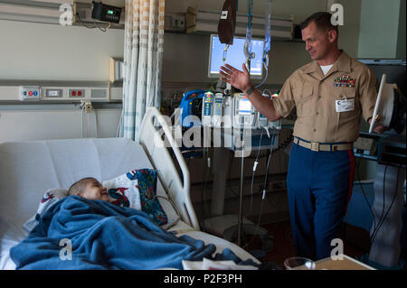 160901-N-VR008-016 ORANGE, Californie (sept. 1, 2016) - Sgt. Le major Michael boucles, affecté à l'hélicoptère léger Marine Attack Squadron 369, traite les navires à un patient à l'Hôpital pour enfants du comté d'Orange, au cours de la première semaine de la flotte de Los Angeles. La semaine de la flotte offre au public l'occasion de visiter les navires, rencontrez marins, marines, et des membres de la Garde côtière et d'acquérir une meilleure compréhension de la façon dont la mer services support la défense nationale des États-Unis et de la liberté des mers. (U.S. Photo par marine Spécialiste de la communication de masse 3 Classe Kyle Goldberg/libérés) Banque D'Images