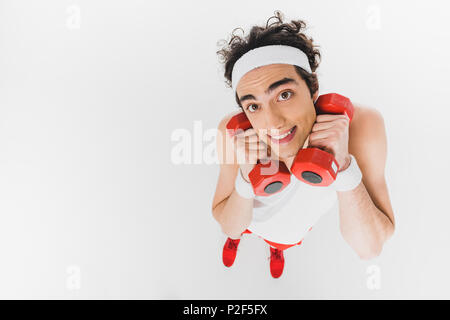 Portrait de skinny sportsman holding dumbbells près de visage isolated on white Banque D'Images