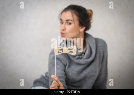 Belle jeune fille avec une moustache sur un bâton en bois,vêtu d'un chandail tricoté confortable Banque D'Images