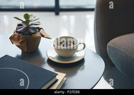 Vue rapprochée de succulentes vert, tasse de café et des livres sur la table à l'intérieur Banque D'Images