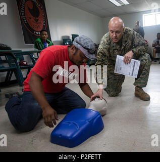 Le Premier maître de la Marine américaine Johnathan Akers avec groupe de contrôle de l'air marin 18, aide un étudiant avec le CP au cours de Valiant Shield 16 au Collège, Tinian Îles Mariannes du Nord, le 15 septembre 2016. Valiant Shield est une bi U.S. Air Force, la Marine et le Marine Corps se tiendra à Guam, en mettant l'accent sur des compétences dans le maintien de forces conjointes en mer, dans les airs, sur terre et dans le cyberespace. (U.S. Marine Corps photo par Lance Cpl. Jordan A. Talley) Banque D'Images