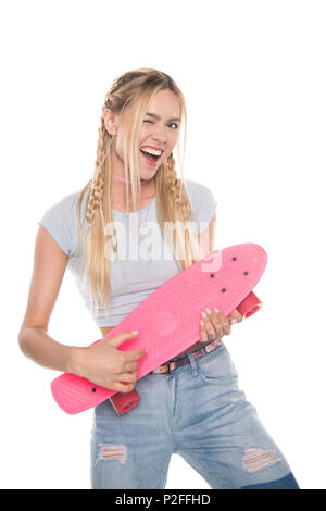Cheerful attractive blonde girl holding skateboard et clignant de l'appareil photo à isolated on white Banque D'Images