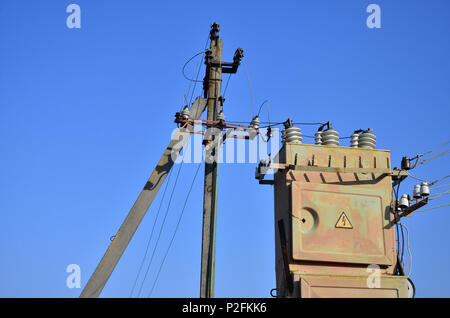 Vieux et obsolètes de transformateur électrique dans le contexte d'un ciel bleu. Dispositif pour la distribution de fourniture de l'énergie à haute tension Banque D'Images