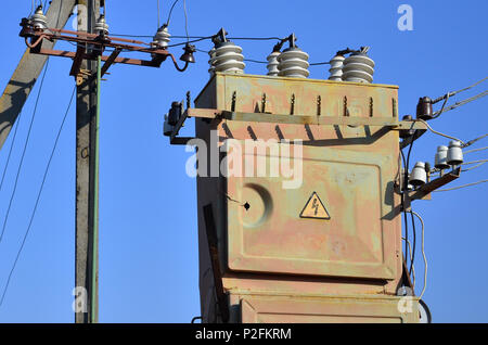 Vieux et obsolètes de transformateur électrique dans le contexte d'un ciel bleu. Dispositif pour la distribution de fourniture de l'énergie à haute tension Banque D'Images