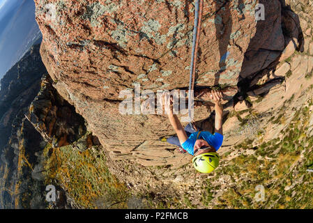 Femme d'escalade sur roche de granit rouge, Mottarone, Piémont, Italie Banque D'Images