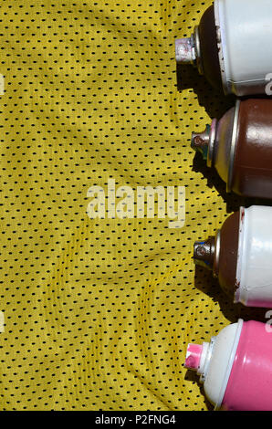 Plusieurs pulvérisateurs de peinture aérosols utilisés se trouvent sur la chemise de sport d'un joueur de basket-ball fait de polyester Tissu. Le concept de l'art de la rue, la jeunesse s'active Banque D'Images
