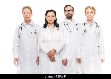 L'équipe multi-ethnique de certains médecins d'âge moyen looking at camera isolated on white Banque D'Images