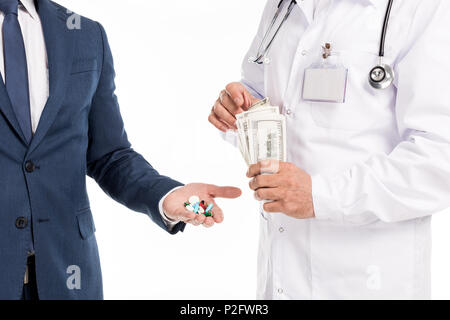 Cropped shot of businessman holding pills tout en comptant les billets de dollar médecin isolated on white Banque D'Images