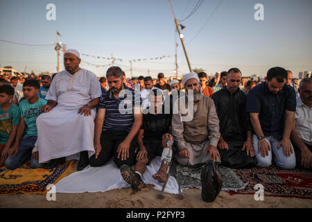 La ville de Gaza, la bande de Gaza. 15 Juin, 2018. Les Palestiniens prennent part à la prière de l'Aïd al-Fitr, une fête de trois jours qui marque la fin de la jeûne musulman mois saint du Ramadan, à la frontière de l'Israel-Gaza est de la ville de Gaza, bande de Gaza, 15 juin 2018. Credit : Wissam Nassar/dpa/Alamy Live News Banque D'Images