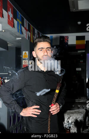 Rusholme, Manchester, Royaume-Uni. Jun 15, 2018. Un homme qui fume un narguilé dans un bar, Rusholme, 15 juin 2018 (C)Barbara Cook/Alamy Live News Banque D'Images