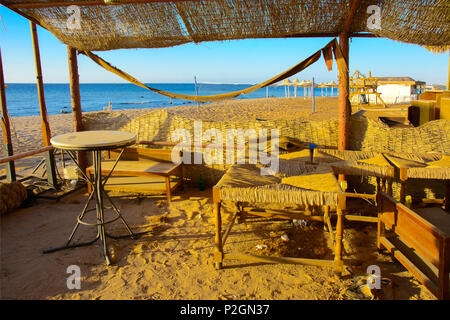 Vieux meubles de plage abandonnée sur une plage vide sur un fond de sable jaune et bleu ciel. Jeté, des choses inutiles. Vacances, tourisme. Banque D'Images