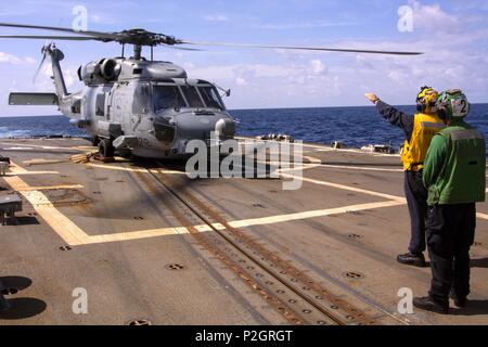 160919-N-CL027-156 OCÉAN INDIEN (sept. 19, 2016) Maître de Manœuvre 3 classe Eric Khabbaz, d'Orange, Californie, attribué à missiles de l'USS Mason (DDG 87), les signaux d'un MH-60R Sea Hawk, affecté à l'hélicoptère de Renards Marais grève Maritime Squadron (HSM) 74, piloté par le lieutenant Cmdr. Lunser Katie, à partir de la Hollande, N.Y., et le lieutenant J.G. Matthew Burgess, de Jacksonville, en Floride, Mason, déployés dans le cadre du groupe aéronaval d'Eisenhower, appuie les opérations de sécurité maritime et les efforts de coopération en matière de sécurité dans le théâtre dans la 5e flotte américaine zone d'opérations. (U.S. Photo par Marine M Banque D'Images